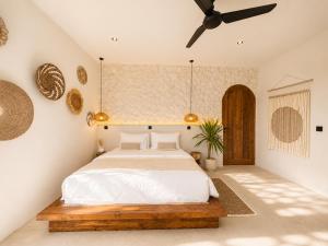 a bedroom with a bed and a ceiling fan at Ôkeanos Boutique Hotel - Uluwatu Ungasan in Uluwatu +96 photos
