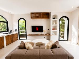 a living room with a couch and a tv at Ôkeanos Boutique Hotel - Uluwatu Ungasan in Uluwatu