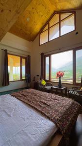 a large bedroom with a large bed with a large window at Falak Stays in Shamshi +12 photos