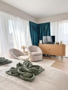 a room with a bed and two chairs and a television at HelloWine Apartman II in Eger