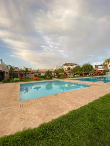 a large swimming pool in the middle of a yard at La ferme labyed in Fez
