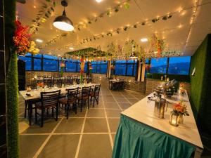 a dining room with tables and chairs and lights at Hotel Royal Dot Managed By Sitara Group, Haridwar in Haridwār