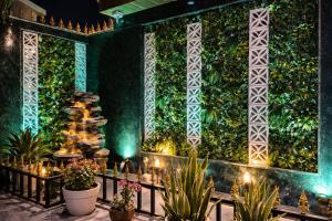 a green wall with a fountain and plants at Hotel Royal Dot Managed By Sitara Group, Haridwar in Haridwār
