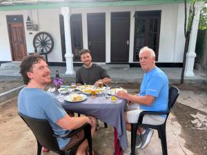 three men sitting at a table eating food at The Wild Lotus YALA in Tissamaharama