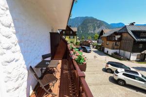 a balcony with flowers on the side of a building at Pension Bergfried in Hallstatt