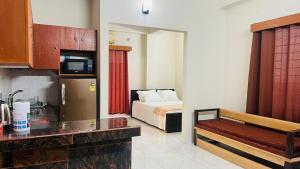 a hotel room with a bed and a kitchen at Best Eastern Apartments - With Balcony & Kitchen in Dhaka
