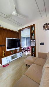 a living room with a couch and a flat screen tv at Indian Bungalows in Vagamon
