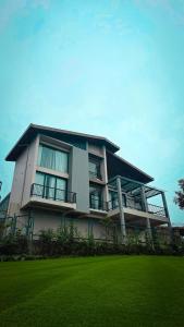 a large building with a green lawn in front of it at Indian Bungalows in Vagamon
