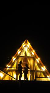 two people standing in front of a building at night at Indian Bungalows in Vagamon