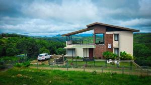 a house with a car parked in front of it at Indian Bungalows in Vagamon +4 photos