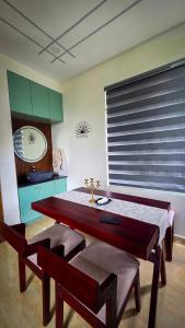 a dining room with a table and two benches at Indian Bungalows in Vagamon