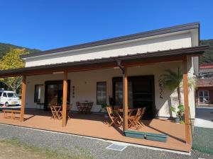 a house with a covered porch with a table and chairs at あらとんとんの宿 in Setouchi