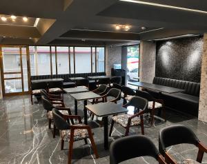a restaurant with tables and chairs and a couch at Hotel Aston Residency in Kolkata