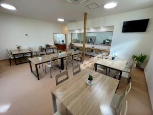 a restaurant with tables and chairs and a flat screen tv at あらとんとんの宿 in Setouchi +26 photos