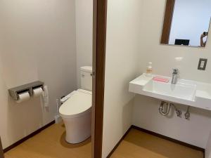 a bathroom with a toilet and a sink at あらとんとんの宿 in Setouchi
