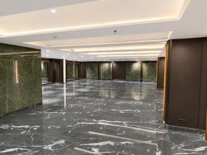 a lobby with a marble floor and a large hall at Hotel Aston Residency in Kolkata