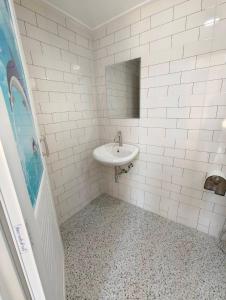 a white bathroom with a sink and a mirror at บ้านนอร์ดิก เฮาส์ เขาค้อ in Khao Kho
