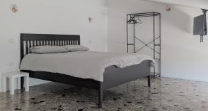 a white bedroom with a large bed and a television at Il quadrifoglio in Serino