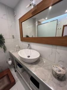 a white bathroom with a sink and a mirror at Costelia Studio in Ialysos