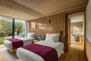 two beds in a room with a window at Six Senses Kyoto in Kyoto +145 photos