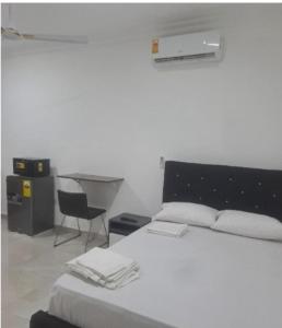 a bedroom with a bed and a desk and a chair at Meg place in Amamoli
