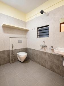 a bathroom with a toilet and a sink at SLV Comforts in Chikmagalūr