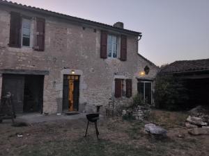 a stone house with a grill in front of it at Au soleil in Virac