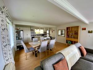 a living room with a couch and a table and chairs at Cable Bay Moana View House in Cable Bay