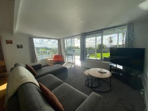 a living room with a couch and a flat screen tv at Cable Bay Moana View House in Cable Bay