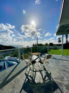 a table and two chairs sitting on a patio at Cable Bay Moana View House in Cable Bay