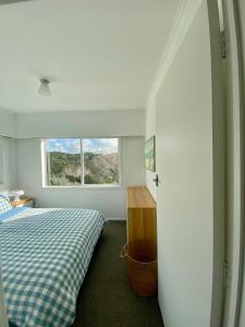 a bedroom with a bed and a window at Cable Bay Moana View House in Cable Bay