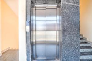 a metal elevator in a room with a staircase at Collection O Kadugodi Tree Park Metro Station Bengaluru Formerly Royal Rooms in Bangalore