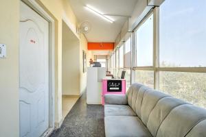 a living room with a couch in front of a window at Collection O Kadugodi Tree Park Metro Station Bengaluru Formerly Royal Rooms in Bangalore