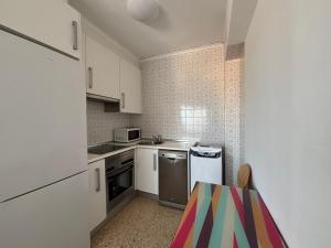 a small kitchen with white appliances and a table at NEW UDYNO in Piles