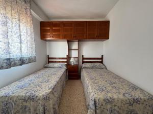 two twin beds in a room with a cabinet at NEW UDYNO in Piles