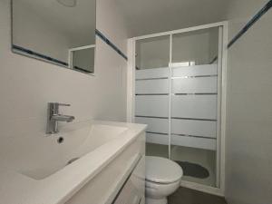 a white bathroom with a toilet and a sink at NEW UDYNO in Piles