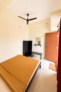 a bedroom with a bed and a flat screen tv at SLV Comforts in Chikmagalūr