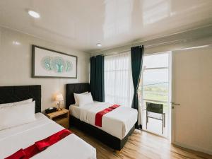 a hotel room with two beds and a window at Bhuana Agung Villa and Restaurant in Jatiluwih