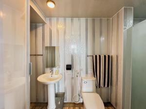 a bathroom with a toilet and a sink and a shower at Bhuana Agung Villa and Restaurant in Jatiluwih