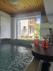 a house with a pool of water with a table at Къща за гости Падалото in Smolyan