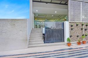 a door to a building with stairs and plants at Townhouse Vikas Nagar Lucknow Formerly Wave BLU in Lucknow