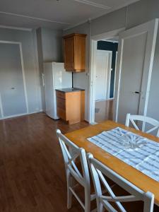a kitchen and dining room with a table and chairs at Leilighet ved vannet in Konsmo