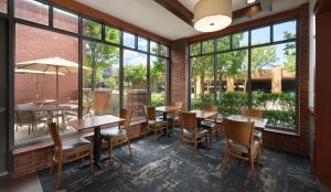 a restaurant with tables and chairs and large windows at Hyatt Place Columbus/OSU in Columbus