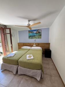 a bedroom with a bed and a ceiling fan at Hostal Playa in Cala Santanyi