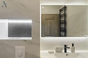 a white bathroom with a sink and a mirror at Apartment in MoonLight Residence in Mamaia +32 photos