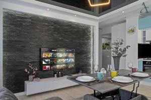 a living room with a dining table and a tv at Apartment in MoonLight Residence in Mamaia
