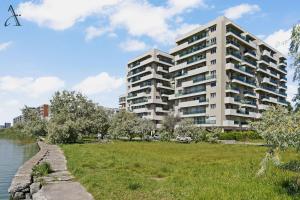 a tall apartment building next to a river at Apartment in MoonLight Residence in Mamaia