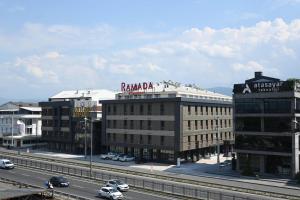 a building with a sign on top of it next to a highway at Ramada by Wyndham Duzce in Duzce