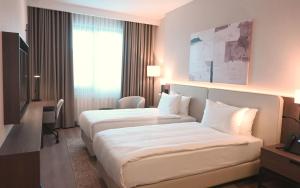 a hotel room with two beds and a desk at Ramada by Wyndham Duzce in Duzce +242 photos