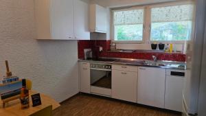 a kitchen with white cabinets and a stove top oven at Ferien auf dem Weingut in Ligerz
